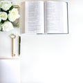 Flat lay with different accessories; flower bouquet, pink roses, open book, Bible