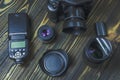 Flat lay with different photoaccessories arranged on dark boards: camera, lenses, battery, charger, synchronizer, and lens covers Royalty Free Stock Photo