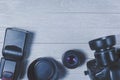 Flat lay with different photoaccessories arranged on the side of the table: camera, lenses, battery, charger, synchronizer, and Royalty Free Stock Photo