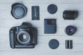 Flat lay with different photoaccessories on boards: camera, lenses, battery, charger, synchronizer, and lens covers Royalty Free Stock Photo