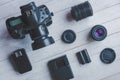 Flat lay with different photoaccessories on white boards: camera, lenses, battery, charger, synchronizer, and lens covers Royalty Free Stock Photo