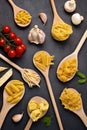 Flat lay with different types of traditional italian pasta. Penne, tagliatelle, fusilli, farfalle, spaghetti and cooking ingredien Royalty Free Stock Photo