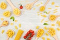 Flat lay with different types of traditional italian pasta. Penne, tagliatelle, fusilli, farfalle, spaghetti and cooking ingredien Royalty Free Stock Photo