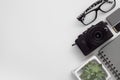 Flat lay of digital camera, battery, sd card, glasses, notebook