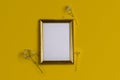 Flat lay with empty golden photo frame and gypsophilia flowers on yellow background