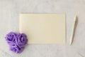 Flat lay fashion mockup: textured card, purple rosses and dip pen on white background