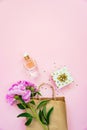 Flat lay of female cosmetics products, gift box and peony flower over pink background. Copy space