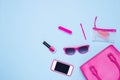 Flat lay of female fashion accessories and white handbag on blue