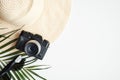 Flat lay female fashion outfit on white table. Top view beach straw hat, vintage camera, sunglasses and tropical palm leaf. Travel Royalty Free Stock Photo