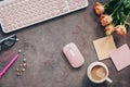 Flat lay female workspace - modern keyboard, mouse, cup of coffee, rose flowers, jewelry and stationery on a dark rustic