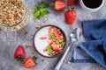Flat-lay Food Concept. Yogurt, granola and strawberries on gray concrete table background Royalty Free Stock Photo
