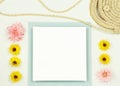 Flat lay frame mockup with summer flowers and straw bag