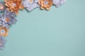 Flat lay frame of vintage color paper flowers design in left corner on blue background. Top view, copy space, floral art Royalty Free Stock Photo