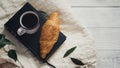 Flat lay of fresh baked croissant with a fresh hot coffee cup on a reading book relaxing cozy mood morning ambience of simple Royalty Free Stock Photo