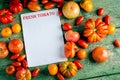 Flat-lay of fresh colorful ripe Fall or Summer heirloom tomatoes variety over rustic background with blank paper top Royalty Free Stock Photo