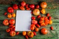 Flat-lay of fresh colorful ripe Fall or Summer heirloom tomatoes variety over rustic background with blank paper top Royalty Free Stock Photo