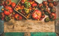 Flat -lay of fresh colorful tomatoes over wooden tray background Royalty Free Stock Photo