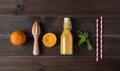 Flat lay with fresh orange juice, citrus fruits, mint, squeezer and paper tube on a brown wooden background. Top  view and copy Royalty Free Stock Photo