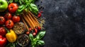 Flat lay of fresh vegetables, pasta, and spices on a dark surface Royalty Free Stock Photo