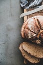Freshly baked sourdough bread loaf and slices, vertical composition