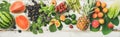 Flat-lay of fruit, vegetables and greens over white wooden background