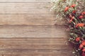 Flat lay of garden spring white and red tiny flowers on wooden plank table background with copy space, retro color style.