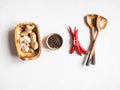 Flat lay of garlic in wood bowl, black pepper in bowl, red chili and wood spoon on light background. top view. Copy space