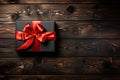 Flat lay gift box with a red bow on a wooden background with copy space. The concept of Black Friday sales