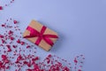 flat lay of gift with red bow next to beads with hearts on very peri color background. holiday concept Royalty Free Stock Photo