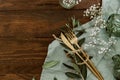 Flat lay gold cutlery, flowers, rings on linen napkin, wedding concept, holiday flowers on wooden Royalty Free Stock Photo