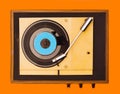 Flat lay gramophone record player from sixties. Turntable for single vinyl on orange background