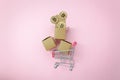 Flat lay graph growth up with coin money & shopping cart or trolley on modern pink paper. Royalty Free Stock Photo