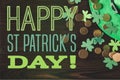 Flat lay with green hat, coins and shamrocks on wooden surface with happy st patricks day Royalty Free Stock Photo