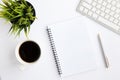 Green plant, coffee, keyboard, notebook and pen