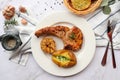 Grilled pork chop steak with baked potato, roasted garlic in white plate and garlic bread on the side - Royalty Free Stock Photo