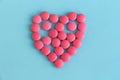 Heart from pink pills on blue background Royalty Free Stock Photo