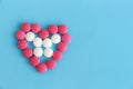 Heart from pink and white pills on blue background Royalty Free Stock Photo