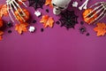 Flat lay Halloween decorations on purple background, top view. Halloween banner mockup with pumpkins, skeleton hands, ghosts,