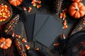 Flat lay of Halloween party invitations surrounded by mini pumpkins, candy corn, and black feathers Royalty Free Stock Photo