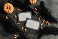 Flat lay of Halloween party invitations surrounded by mini pumpkins, candy corn, and black feathers Royalty Free Stock Photo