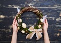 Flat lay of hands holding a handmade willow wreath