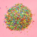 flat lay of heap sprinkles on pink background, top view