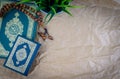 Flat lay Holy Quran with arabic calligraphy meaning of Al Quran and tasbih or rosary beads over wooden paper background