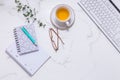 Flat lay home business desk with communication device with cup of tea and writing tools Royalty Free Stock Photo