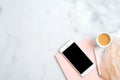 Flat lay home office desk. Female workspace with pink paper notebook, smartphone screen mockup, cup of coffee, pen on marble table Royalty Free Stock Photo