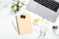 Flat lay home office desk. Women workspace with laptop computer, diary, flowers bouquet, golden accessories on white marble