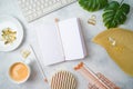 Flat lay home office feminine table with notebook, golden accessories, computer keyboard and tropical leaves on grey background. Royalty Free Stock Photo