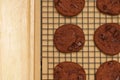 Flat lay of homemade sweets, Chocolate cookies on rack with wooden tray on wood background Royalty Free Stock Photo