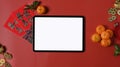 Flat lay a digital tablet with blank screen and accessories Chinese new year festival on red background. Blank screen. Royalty Free Stock Photo
