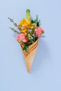 Flat lay Ice Cream Cones with colorful bouquet on blue background Royalty Free Stock Photo